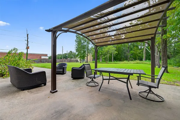 a view of a patio with a table chairs and a yard