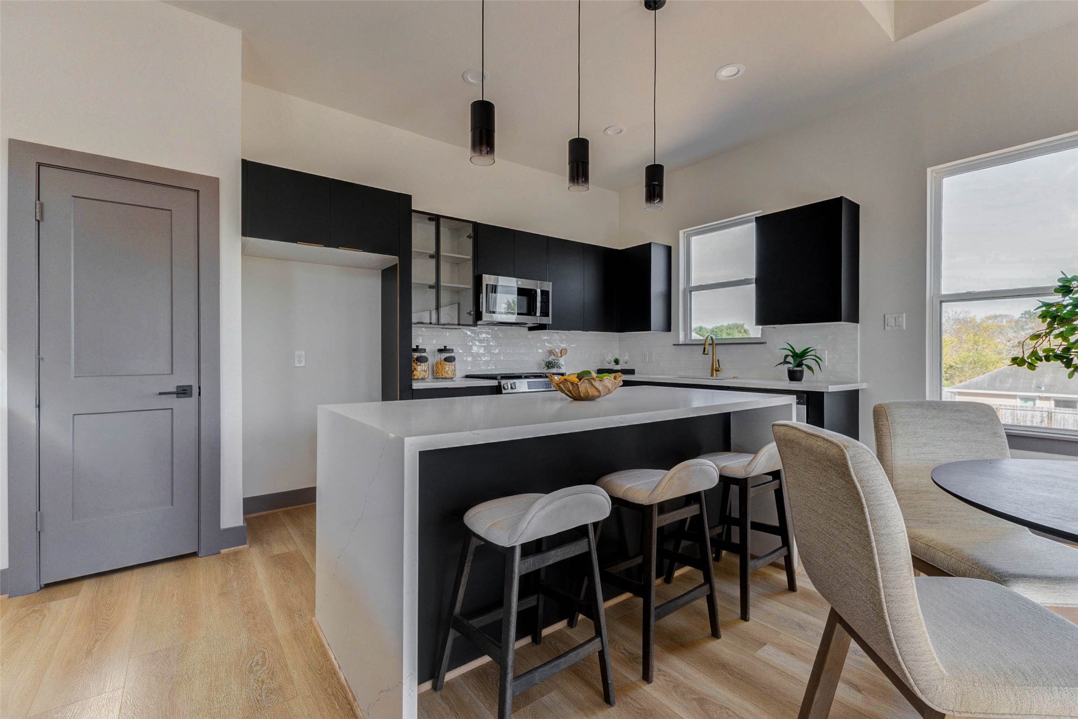 4803 Paula Street Houston, TX 77033 - Photo 8 of 28 The high ceiling and contemporary pendant lighting is complemented by large windows for natural light, creating a bright and inviting space and adding to the open air ambience in the kitchen.