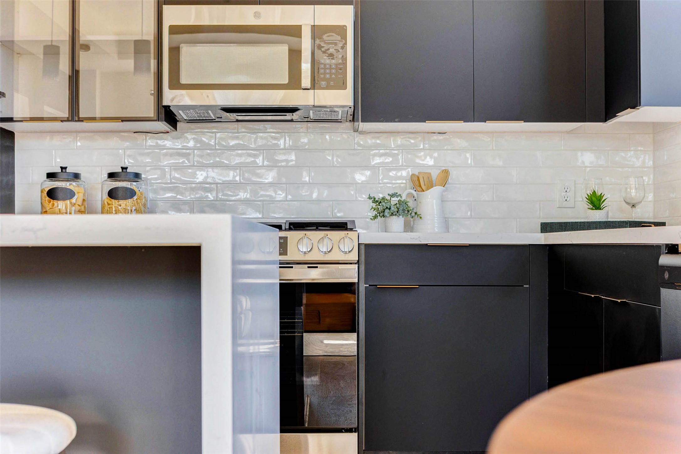 4803 Paula Street Houston, TX 77033 - Photo 9 of 28 The white subway tile backsplash and light countertops add a bright, contemporary touch and contrast against the black cabinetry.