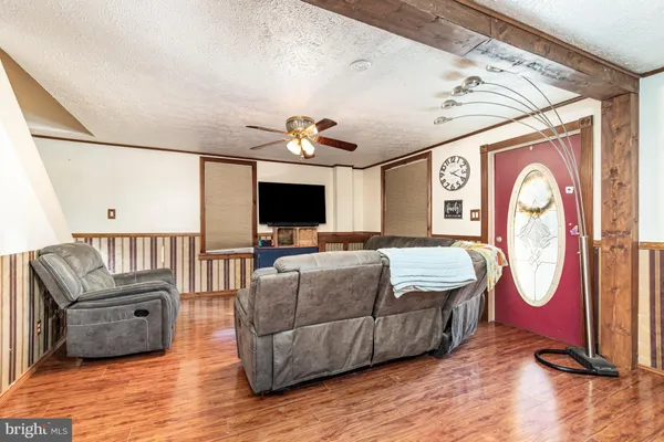 a living room with furniture and a ceiling fan