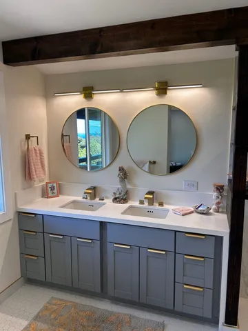 a en suite bathroom with 2 sink and a mirror