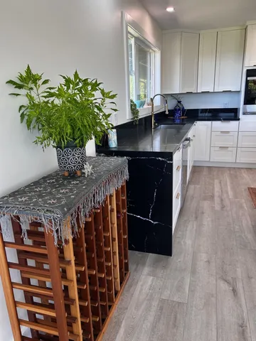 a kitchen with stainless steel appliances granite countertop a sink a stove a microwave a counter top space and cabinets