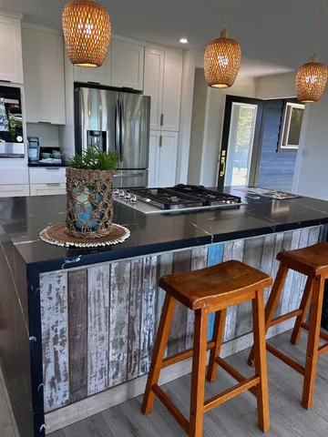 a kitchen with stainless steel appliances granite countertop a stove a sink and a refrigerator