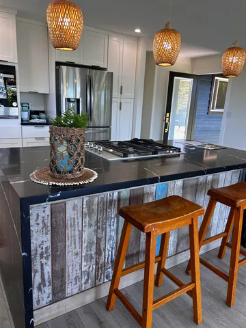 a kitchen with stainless steel appliances granite countertop a stove a sink and a refrigerator