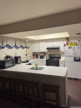 a kitchen with a sink cabinets and wooden floor