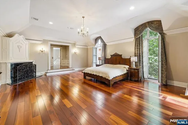 a spacious bedroom with a bed and wooden floor