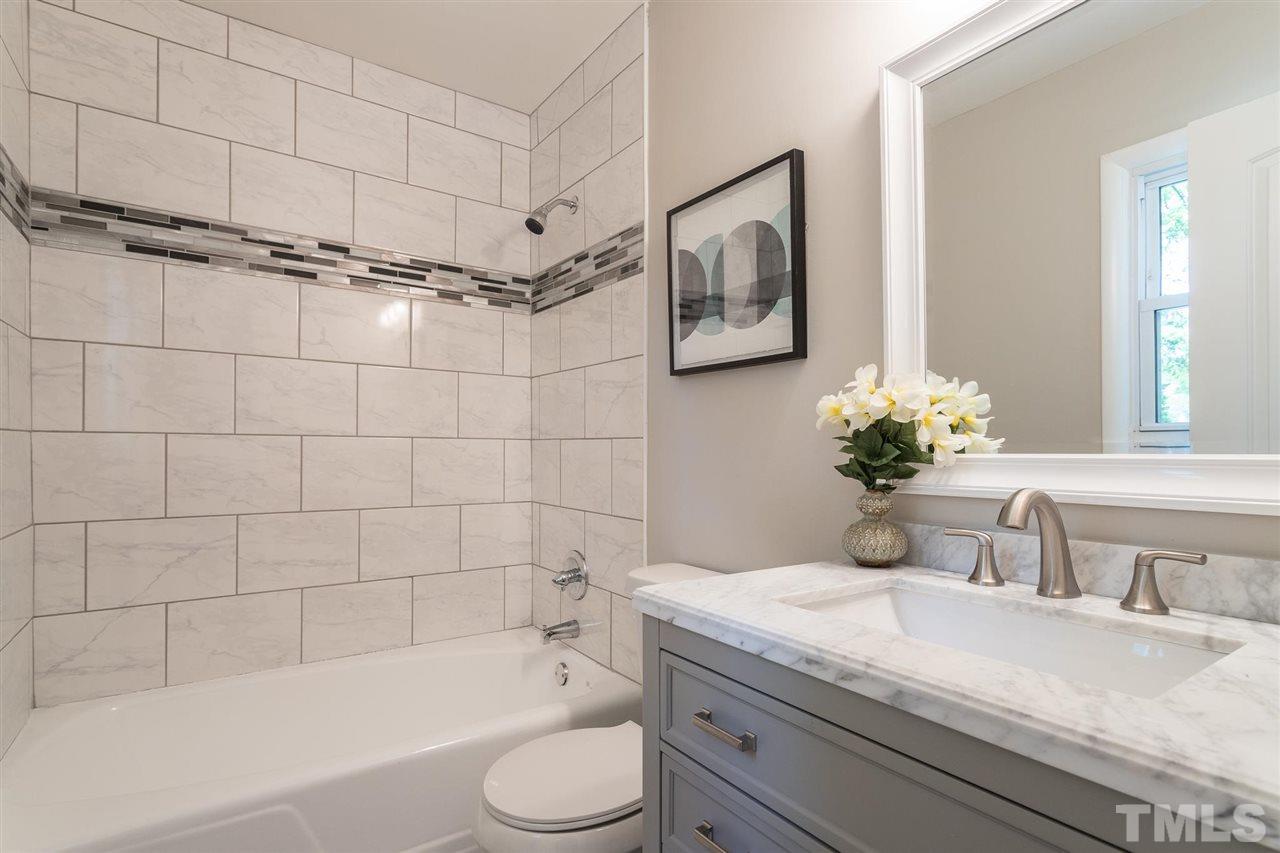 508 Cooper Road Raleigh, NC 27610 - Photo 6 of 25 a bathroom with a granite countertop sink a toilet and bathtub