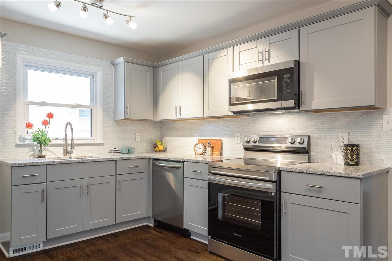 508 Cooper Road Raleigh, NC 27610 - Photo 7 of 25 a kitchen with stainless steel appliances granite countertop white cabinets a sink and a stove