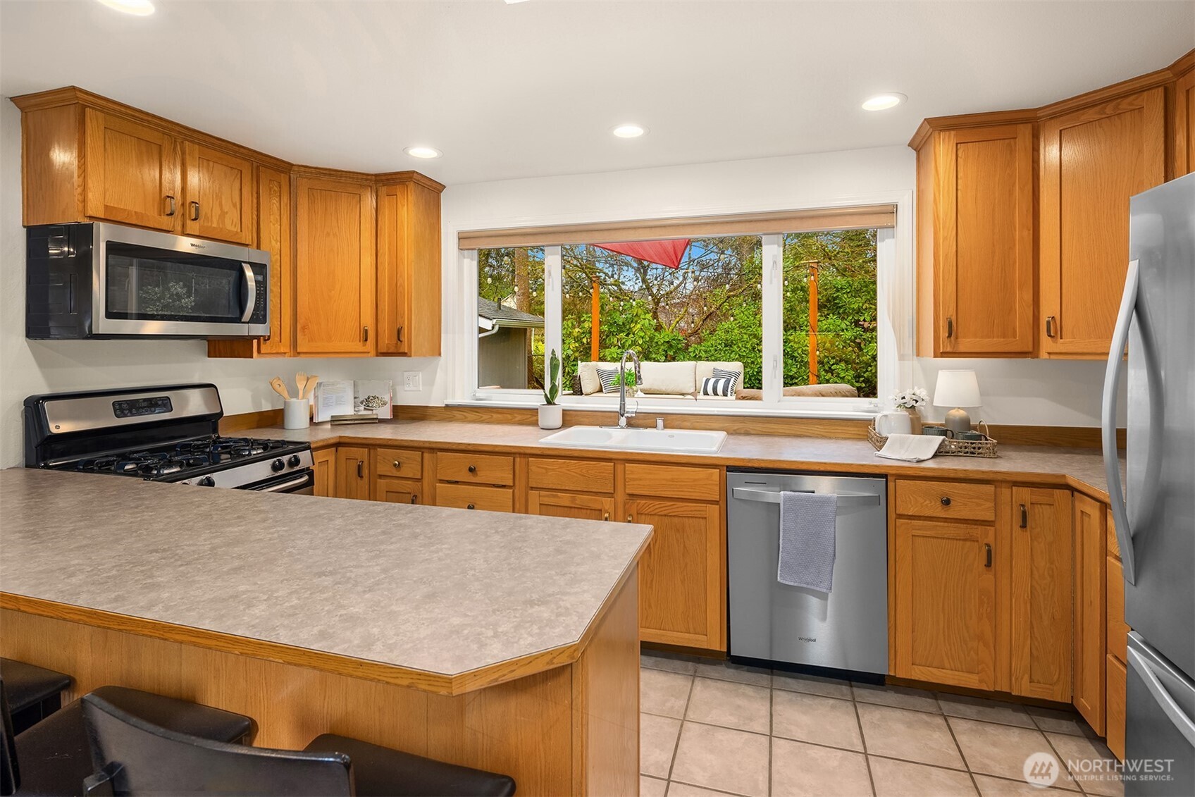 19814 10th Drive Southeast Bothell, WA 98012 - Photo 10 of 40 a kitchen with stainless steel appliances granite countertop a sink counter space cabinets and a window