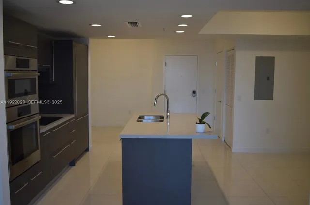 a kitchen with kitchen island stainless steel appliances a sink and a refrigerator