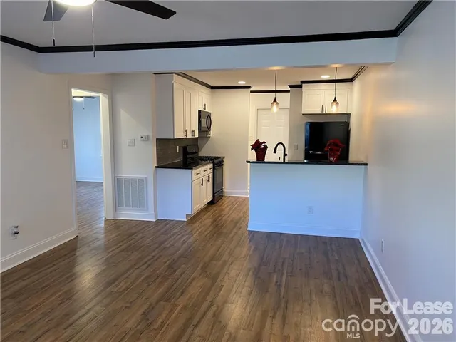 a kitchen with cabinets and wooden floor