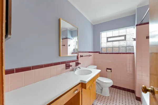 a bathroom with a sink a toilet a mirror and shower