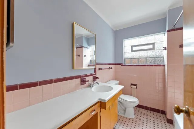 a bathroom with a sink a toilet a mirror and shower