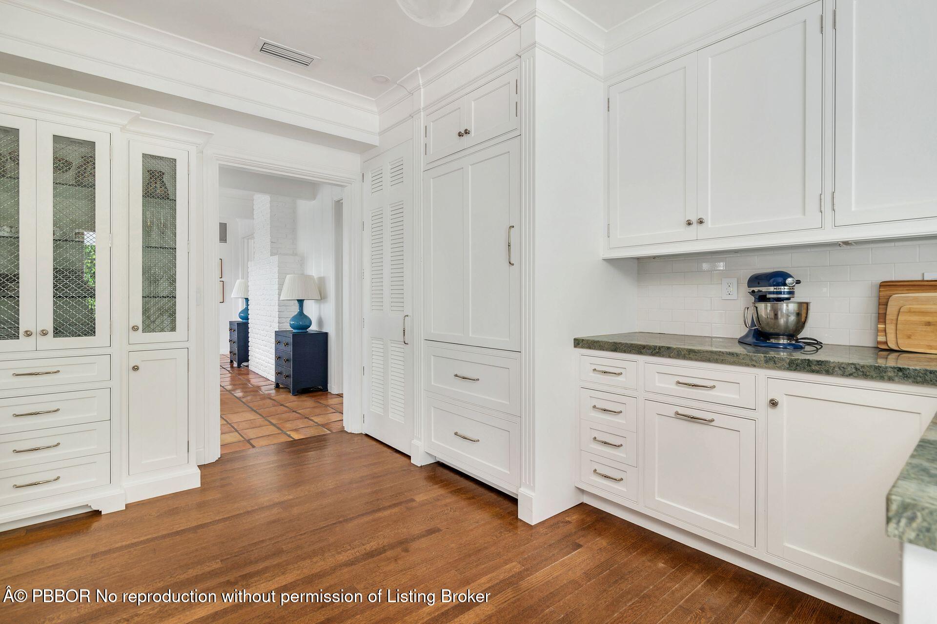 255 Colonial Lane Palm Beach, FL 33480 - Photo 11 of 32 a kitchen with white cabinets and wooden floors