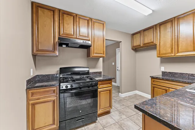 a kitchen with granite countertop wooden cabinets and stainless steel appliances