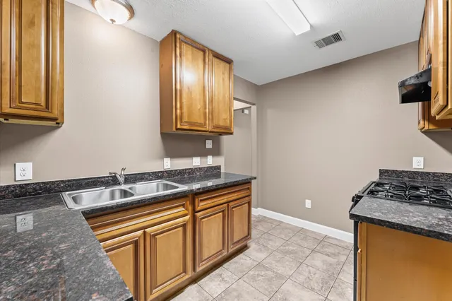 a kitchen with stainless steel appliances granite countertop a sink stove and cabinets