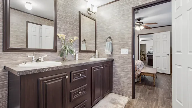 a bathroom with a sink a toilet a mirror and shower