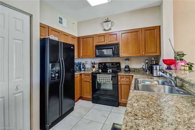a kitchen with stainless steel appliances granite countertop a refrigerator stove top oven a sink and dishwasher