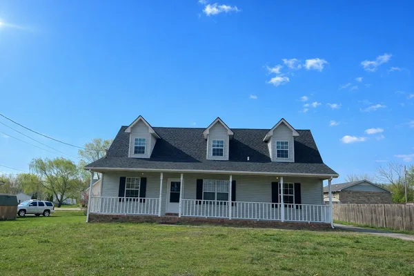 a front view of a house with a garden and yard
