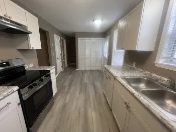 a kitchen with granite countertop cabinets sink and window