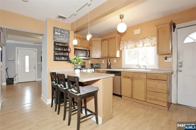a kitchen with a dining table chairs sink and cabinets