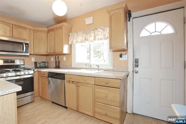a kitchen with cabinets appliances and a window