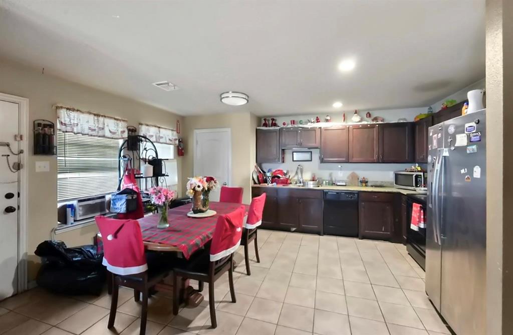 4920 Peachtree Road Balch Springs, TX 75180 - Photo 3 of 7 a kitchen with stainless steel appliances kitchen island granite countertop a refrigerator a stove and a sink with dishwasher