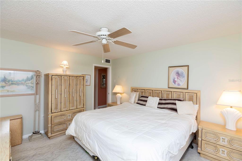 4533 Marine Parkway, Unit 206 New Port Richey, FL 34652 - Photo 12 of 22 a bedroom with a large bed and a chandelier