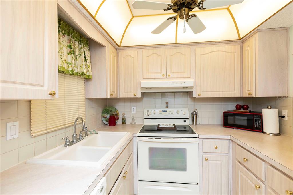4533 Marine Parkway, Unit 206 New Port Richey, FL 34652 - Photo 5 of 22 a kitchen with stainless steel appliances granite countertop a sink a stove and cabinets