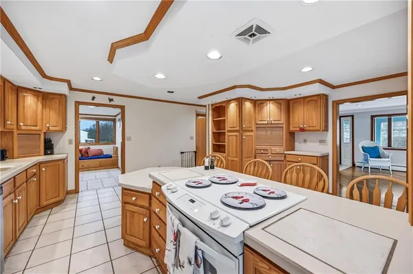 a kitchen that has a stove and a view of living room