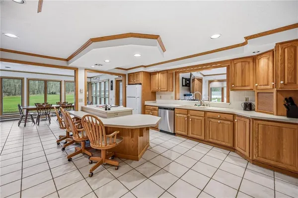 a dining hall with stainless steel appliances a dining table and chairs