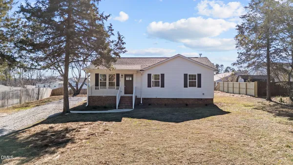 a front view of a house with a yard covered in snow