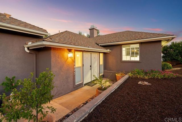 a kitchen with stainless steel appliances kitchen island granite countertop a dining table chairs refrigerator and sink