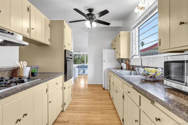 a kitchen with sink a stove and cabinets