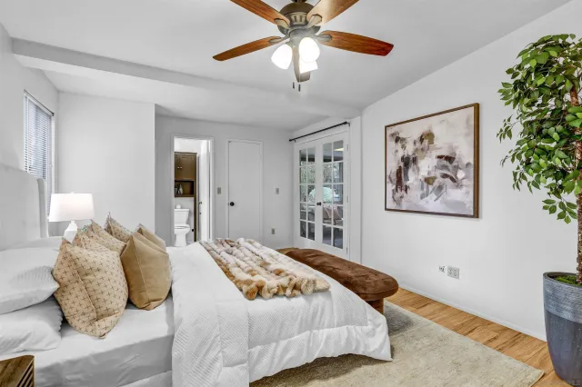 a bedroom with a large bed and a chandelier