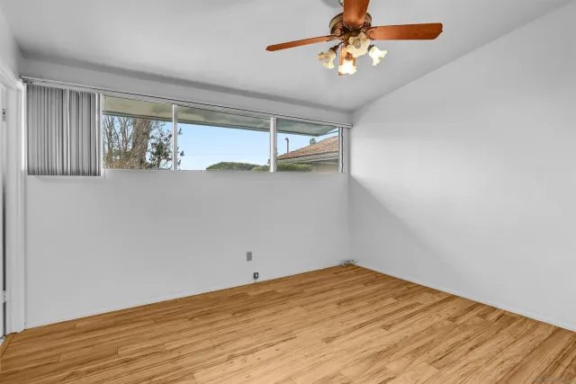 a view of a room with wooden floor and fan