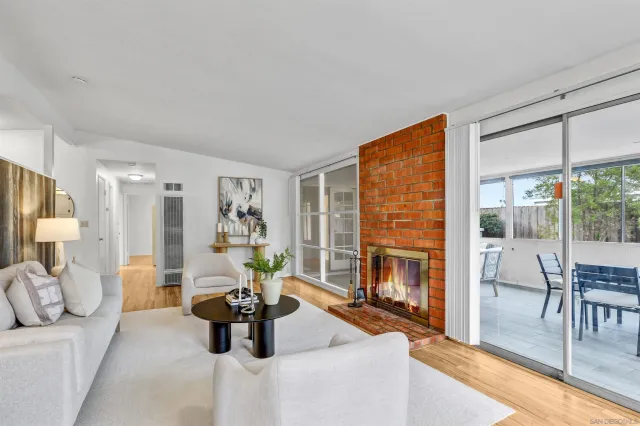 a living room with fireplace furniture and a floor to ceiling window