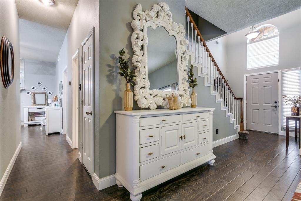 2133 Rim Rock Drive Keller, TX 76248 - Photo 8 of 37 Hallway with dark wood finished floors, stairs, a textured ceiling, and a high ceiling