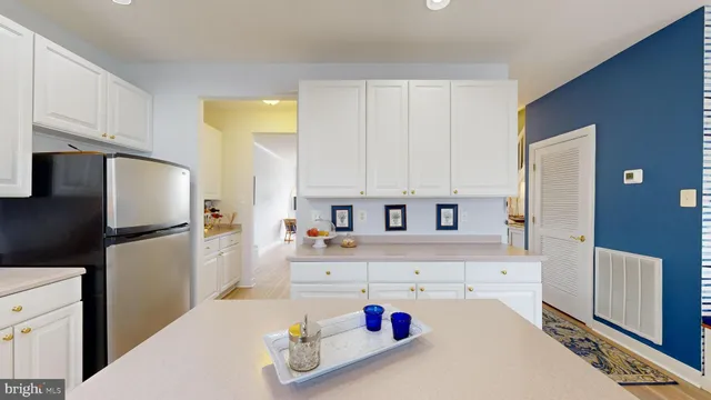 a kitchen with stainless steel appliances a refrigerator sink and white cabinets