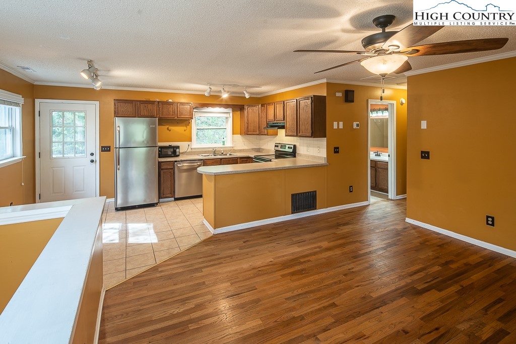 1135 Hopewell Church Road Boone, NC 28607 - Photo 4 of 21 a kitchen with stainless steel appliances granite countertop a refrigerator a stove and a wooden floors