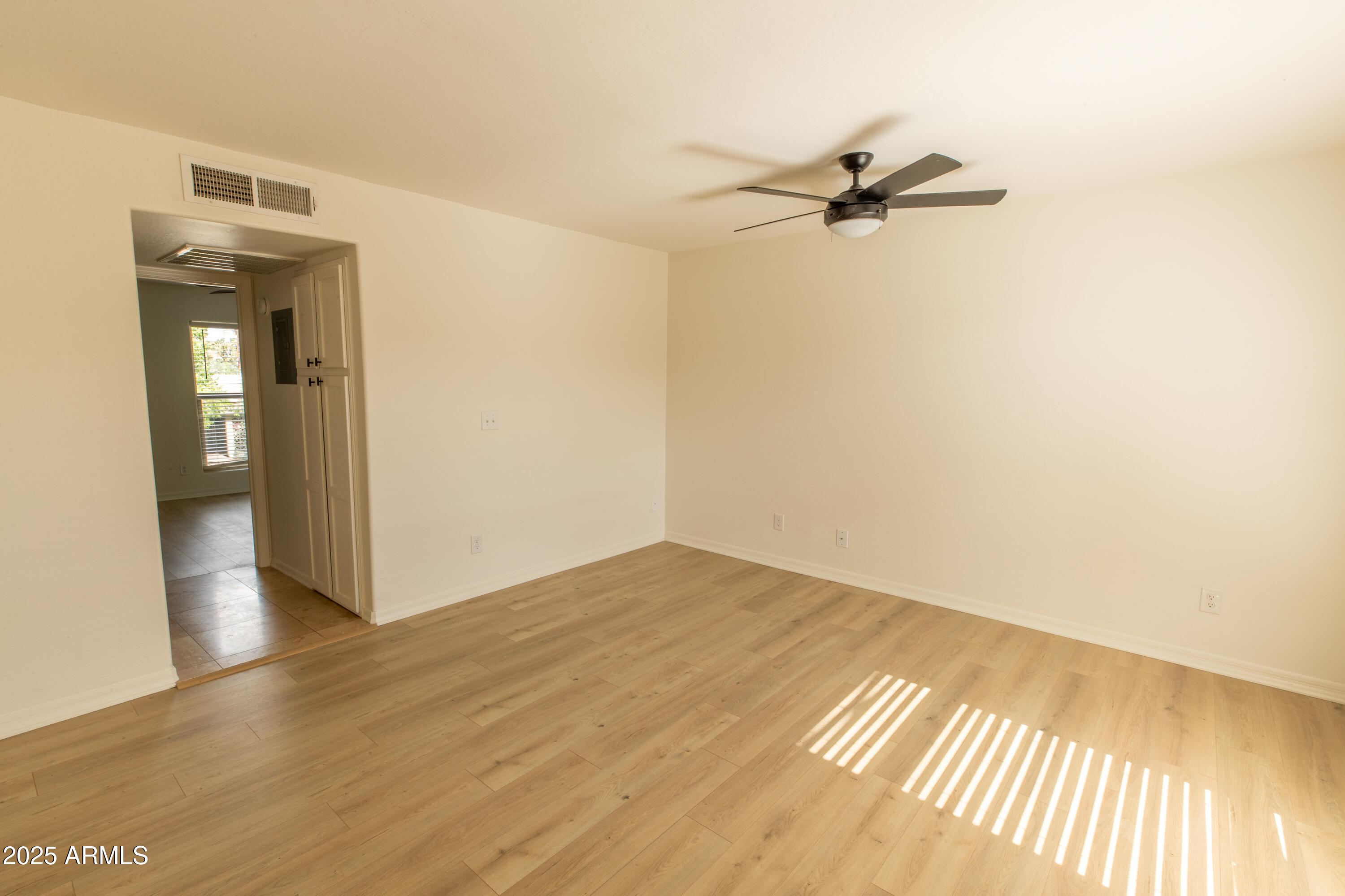 3619 East Monterosa Street, Unit 202 Phoenix, AZ 85018 - Photo 6 of 20 a view of empty room with wooden floor and fan