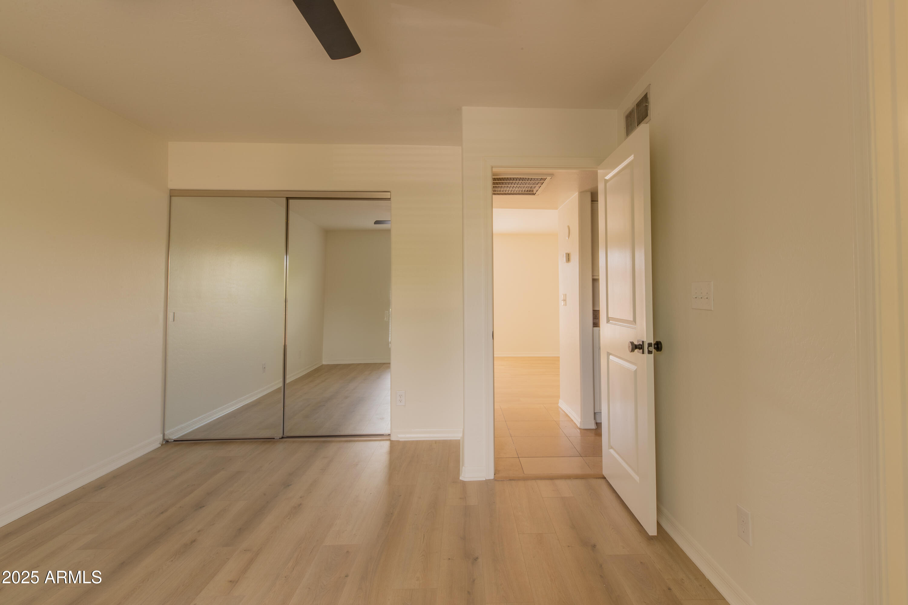 3619 East Monterosa Street, Unit 202 Phoenix, AZ 85018 - Photo 9 of 20 a view of an empty room with wooden floor and a window