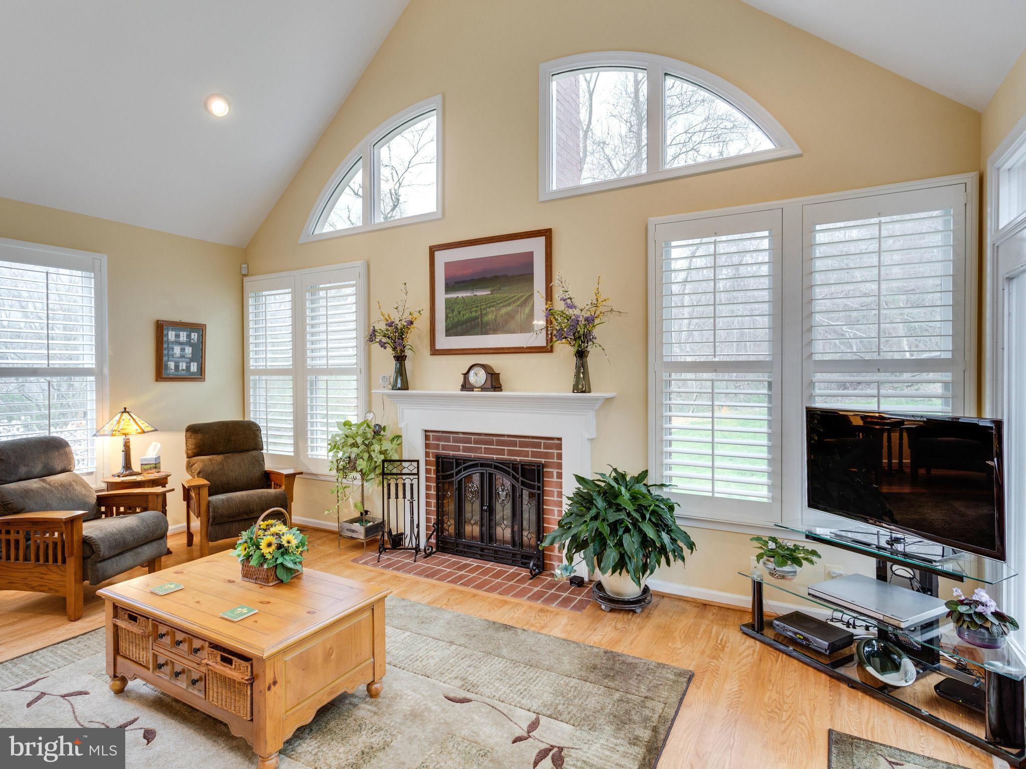 12515 Chapel Road Clifton, VA 20124 - Photo 8 of 30 a living room with furniture a fireplace a flat screen tv and a large window