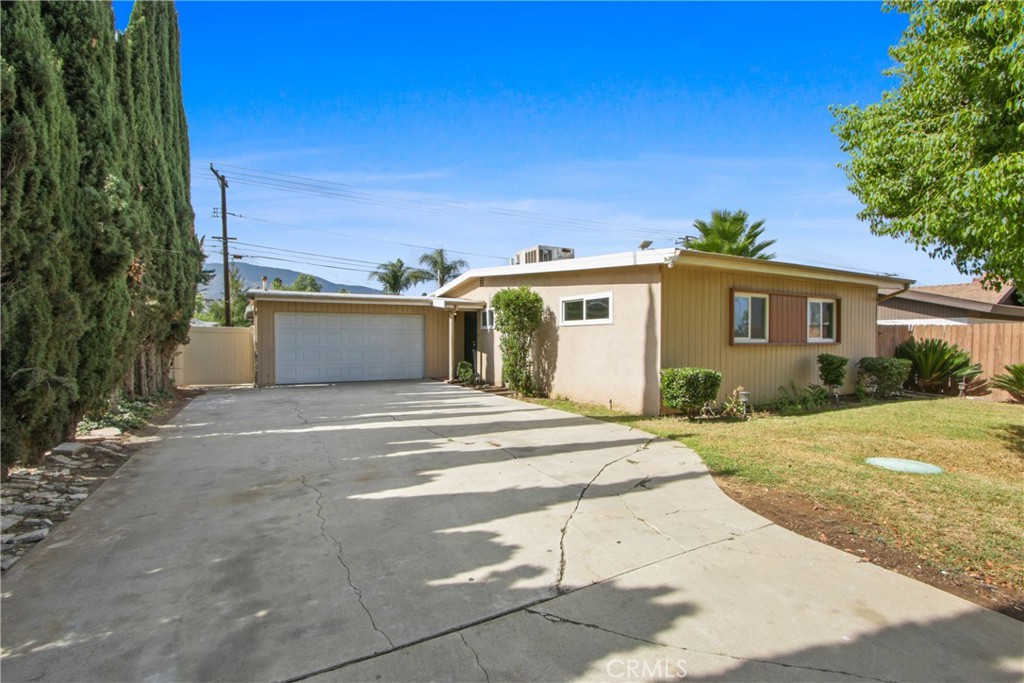 a view of a house with backyard and trees
