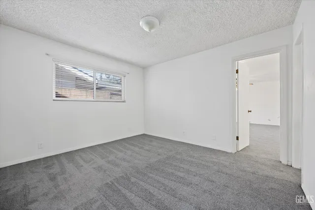 a view of an empty room with a ceiling fan and window