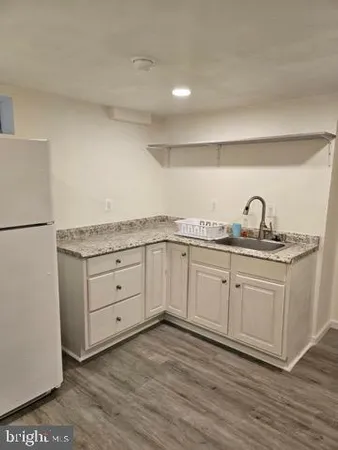 a kitchen with granite countertop cabinets stainless steel appliances a sink and wooden floor