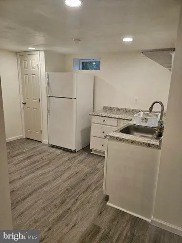 a kitchen with wooden floor and cabinets