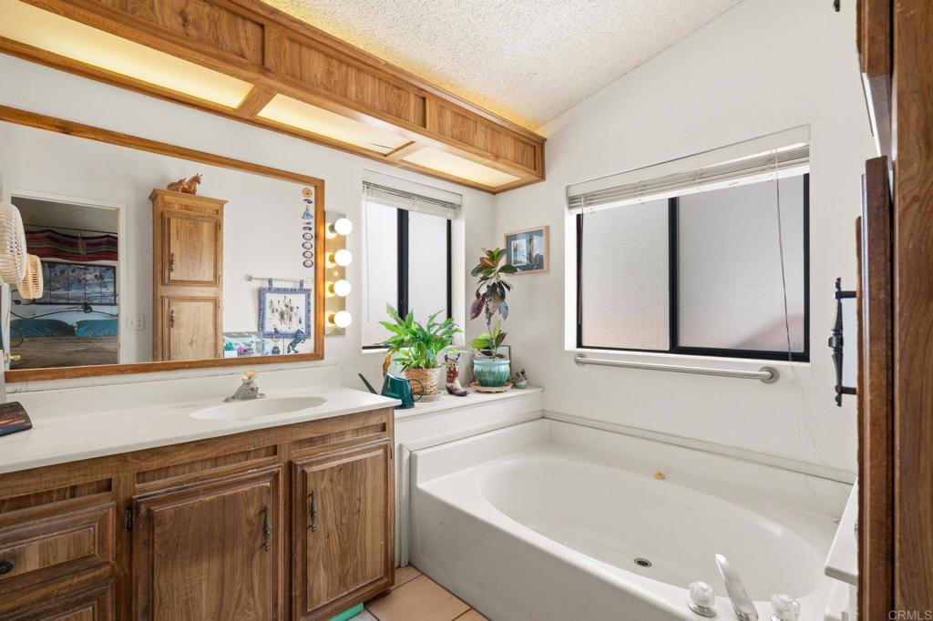 37852 Montezuma Valley Road Ranchita, CA 92066 - Photo 15 of 35 a bathroom with a granite countertop sink and a bathtub