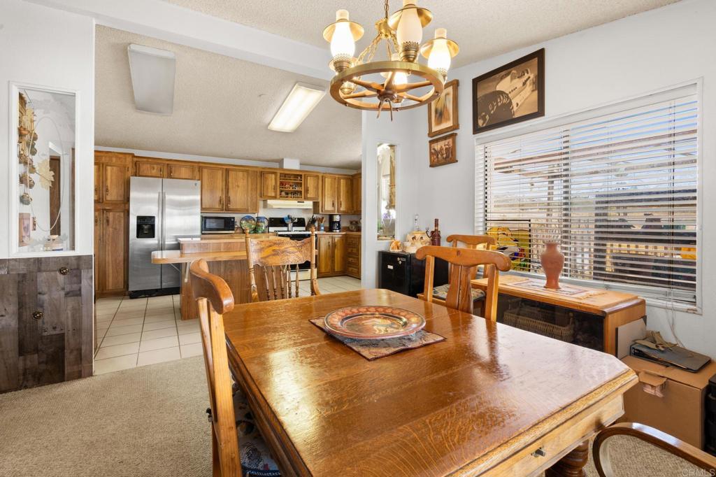 37852 Montezuma Valley Road Ranchita, CA 92066 - Photo 9 of 35 a dining room with wooden floor a chandelier a wooden table and chairs
