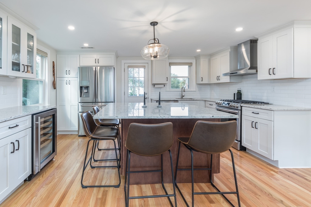 59 Florence Road Waltham, MA 02453 - Photo 8 of 20 a kitchen with stainless steel appliances granite countertop a sink a stove a refrigerator dining table and chairs